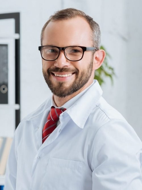 portrait-of-smiling-male-chiropractor-in-white-coat-and-eyeglasses-with-notepad-in-hospital-e1630005297244.jpg